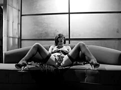 Bobbi wears a corset and stockings while she pleases herself