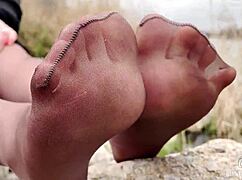 Goddess in spring forest teases with feet in tan pantyhose