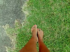 African pornstar walks barefoot on beach and street, dirtying feet.