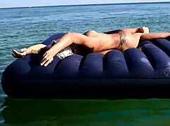 Beautiful blonde girl enjoys nude beach with big boobs and dolphin tattoo in public nudist outdoor setting