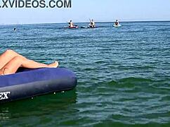 Beautiful blonde girl enjoys nude beach with big boobs and dolphin tattoo in public nudist outdoor setting